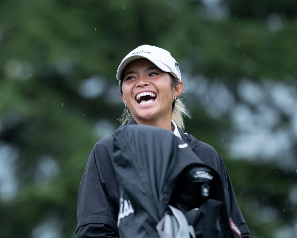 Golfer smiling in black rain jacket